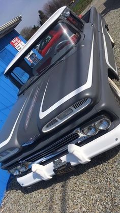 the front end of a car that has been painted black and white with silver stripes