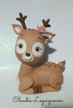 a ceramic figurine of a deer with a flower in its antlers'hair