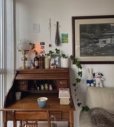 a living room filled with furniture next to a window and a painting on the wall