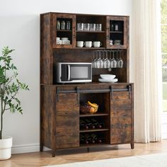 a wooden cabinet with wine glasses and a microwave