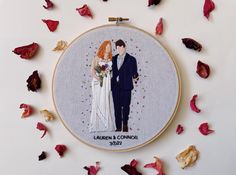 a wedding portrait is featured in this embroidery art piece, surrounded by dried rose petals