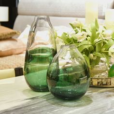 three vases sitting on a table with flowers in them