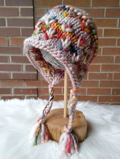 a knitted hat on top of a wooden stand