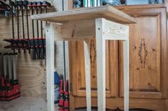 a wooden table sitting in the middle of a room next to a bunch of tools