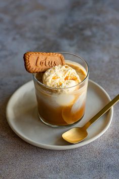 a dessert in a glass on a plate with a spoon