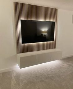 a television mounted on the side of a wall in a room with carpeted flooring