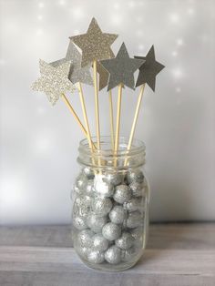 some silver and gold stars in a glass jar