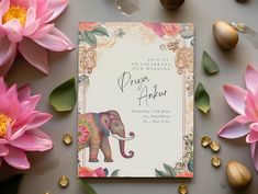 a wedding card with an elephant on it surrounded by pink flowers and gold foil decorations