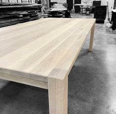 a wooden table sitting inside of a warehouse