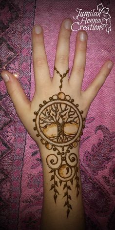 a woman's hand is decorated with hennap and an intricate tree design