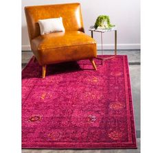 an orange chair sitting on top of a pink rug next to a brown leather chair