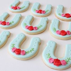 decorated cookies are arranged in the shape of letters with roses and leaves on each cookie