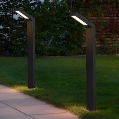 three modern outdoor lighting posts in the grass