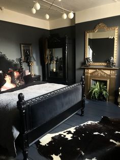 a black and white bedroom with cow hide rugs on the floor next to the bed