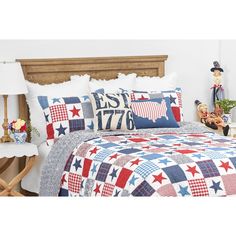 a bed with red, white and blue quilts on it