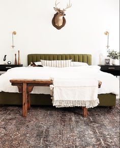 a bed with a wooden headboard sitting on top of a rug next to a night stand