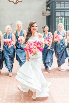 the bride and her bridal party are all dressed in blue dresses with pink bouquets