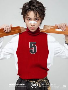 a young man holding two wooden boards on his shoulders with the number 5 taped to his face