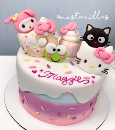 there is a cake decorated with hello kitty and cupcakes on the top tier