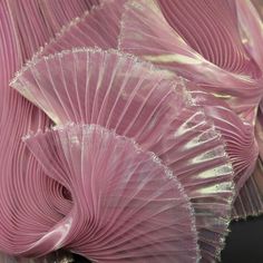 close up view of pink pleated fabric on black table cloth with silver foiled edges