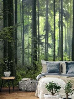 a bed room with a neatly made bed next to a forest wall mural on the wall