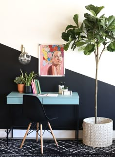 a room with a desk, chair and potted plant on the table in front of it