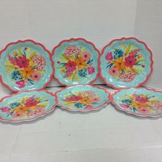 four plates with flowers painted on them