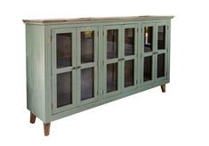 a green cabinet with glass doors and wooden legs