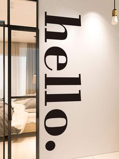 a white wall with the word utopia written on it in black lettering, next to a bed