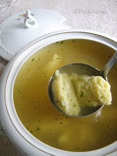 a spoon full of soup with dumplings in it