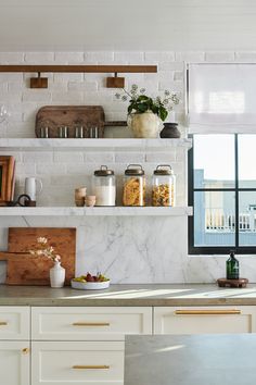 the kitchen counter is covered with jars and containers