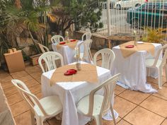 tables and chairs with white tablecloths are set outside