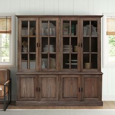 a large wooden china cabinet with glass doors