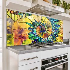 a kitchen with a stove top oven next to a painting on the wall above it