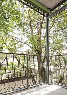 an open balcony with a tree in the background