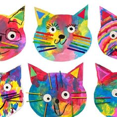 four different colored paper plates with cat faces painted on them, one has eyes and the other has ears