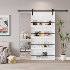 a living room with a white book shelf next to a couch and potted plant