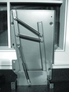 an open door with metal bars on the bottom and sides in front of a window