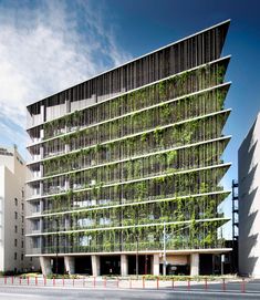 an office building with plants growing on the side of it's front wall and windows