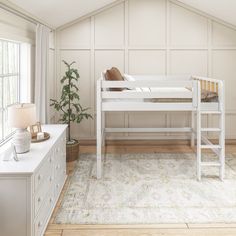 a white bunk bed sitting in the middle of a room next to a dresser and window