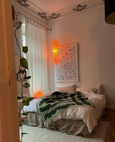 a bedroom with a bed, plant and window