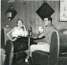 a man and woman sitting at a table in a restaurant