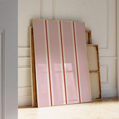 a pink and white striped art piece in an empty room