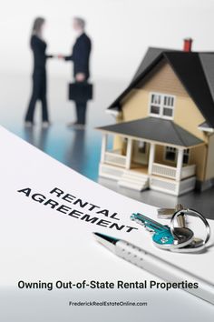 two people shaking hands in front of a rental agreement with keys on top of a real estate document