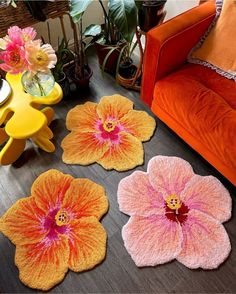 three flower shaped rugs sitting on top of a wooden floor next to a couch