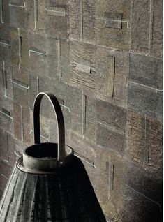 a metal lantern sitting on top of a wooden table next to a wall covered in bricks