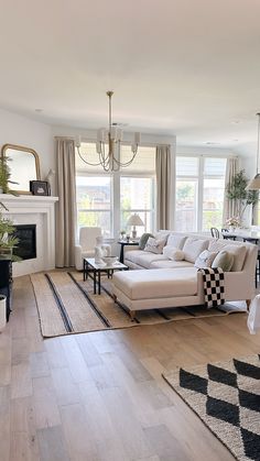 a living room filled with furniture and a fire place in front of a large window