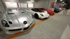 several different colored sports cars lined up in a parking garage