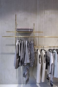 a rack with clothes hanging on it next to a wall