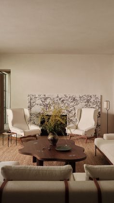 a living room with couches, chairs and a coffee table in front of a fireplace